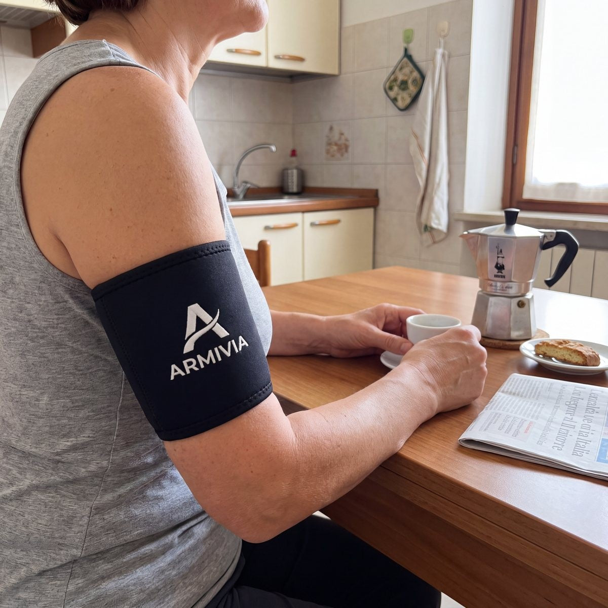The Armivia sleeve worn on the arm, side view, with a cup of coffee