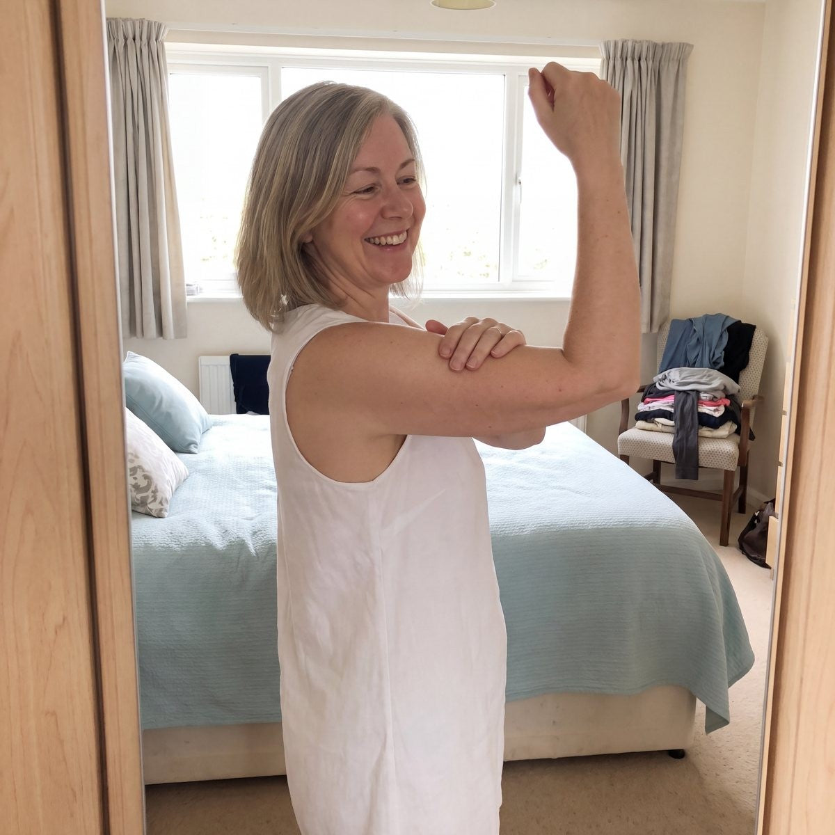 Woman at the mirror touching her arm, relieved